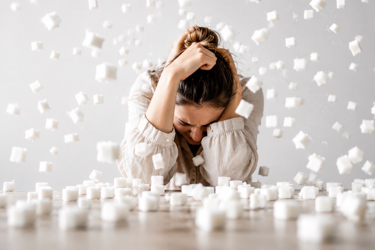 Femme en surcharge, submergée par des morceaux de sucre
